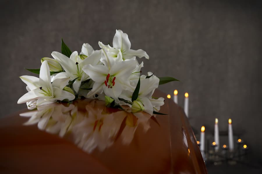 Closed Wooden Casket With White Flowers On